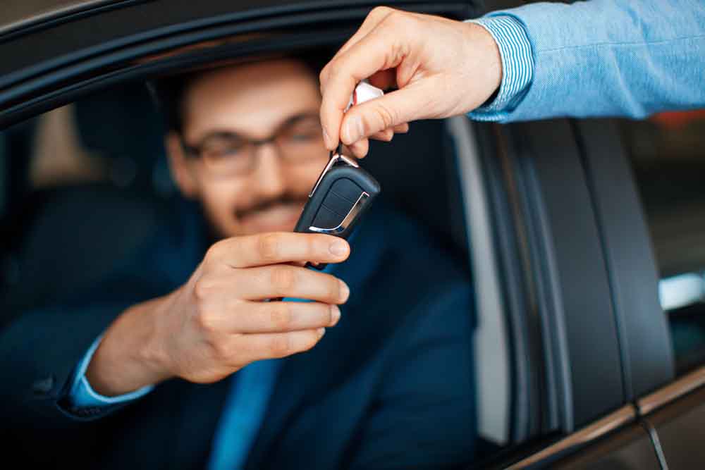 Car salesman handing the keys to the customer Motor Vehicle Finance, smart financing